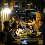 People are enjoying a meal outdoors at night