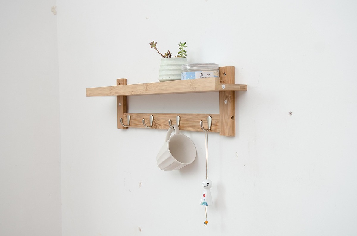 Étagère en bois fixée au mur, crochets, tasse suspendue, petite plante
